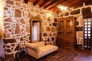 a room with a stone wall with a chair and a cabinet at Finca Vilaflor in Vilaflor