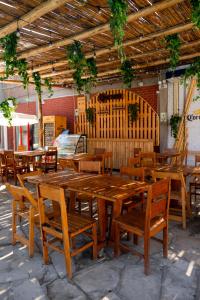 a group of wooden tables and chairs in a restaurant at Hotel Luna Nueva in Colán