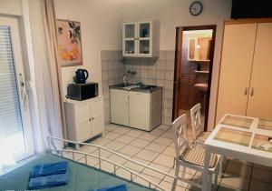 a small kitchen with a table and a refrigerator at Villa Abelia in Medulin