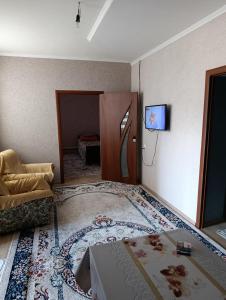 a room with a bed and a tv on the wall at Yrys quest home in Balykchy