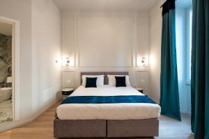 a bedroom with a large bed with blue curtains at Aethel Guesthouse in Rome