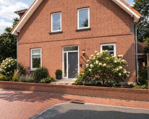 a red brick house with a front door at Monteurwohnungen in Andervene in Andervenne Oberdorf
