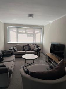 a living room with a couch and a tv at Beautiful Spacious Flat in Oxford