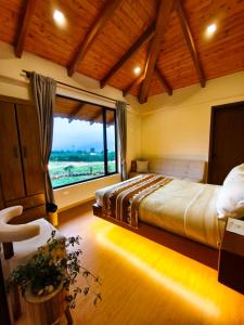 a bedroom with a large bed with a large window at Laguna de Cuicocha Guest House in Urcusiqui