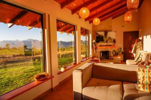 a living room with a couch and a large window at Laguna de Cuicocha Guest House in Urcusiqui