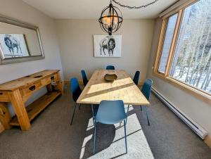 a dining room with a wooden table and blue chairs at Argentine 1516 by SummitCove Lodging in Colorado in Keystone