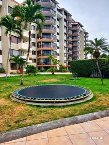 a trampoline in a park in front of a building at Tonsupa Playa Almendro in Tonsupa