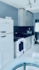 a white kitchen with a stove and a refrigerator at Bedford Station Rest Stop in Bedford