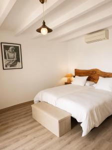 a white bedroom with two beds and a table at Apartamentos La Iguana in Hervás +82 photos
