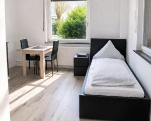 a bedroom with a bed and a table and a window at Monteurwohnungen in Andervene in Andervenne Oberdorf