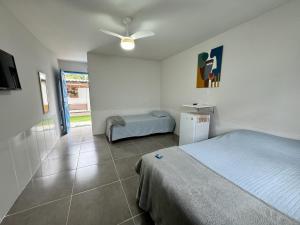 a bedroom with a bed and a table in it at Hanuá Beach House in Guarapari +51 photos