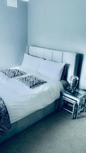 a bed in a room with a side table next to it at Bedford Station Rest Stop in Bedford