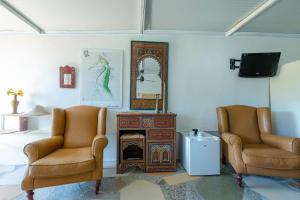 a living room with two chairs and a mirror at Jacaranda in Cádiz +16 photos