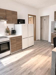 an empty kitchen with white appliances and wooden floors at Monteurwohnungen in Andervene in Andervenne Oberdorf +51 photos
