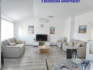 a living room with two couches and a tv at Apartments Miraflor, city center in Crikvenica