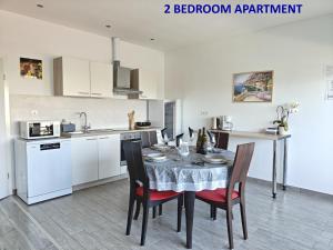 a kitchen with a table and chairs in a room at Apartments Miraflor, city center in Crikvenica
