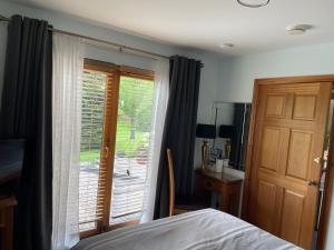 a bedroom with a bed and a sliding glass door at Old Mills Garden in Elgin +10 photos