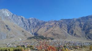 a town in the middle of a mountain range at Red Stone Guest House in Kazbegi