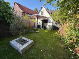 a garden with a bench and an umbrella in a yard at Tiny House am See Dillich - Schwimmteich - Klimaanlage - Hunde willkommen - Eigener Garten in Borken