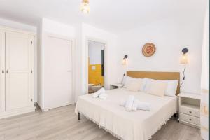 a white bedroom with a large bed with white sheets at Domu Fama in Tertenìa