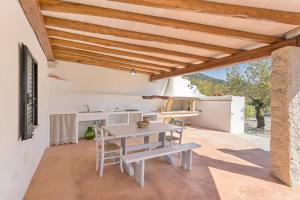 a kitchen and dining room with a table and benches at Domu Fama in Tertenìa
