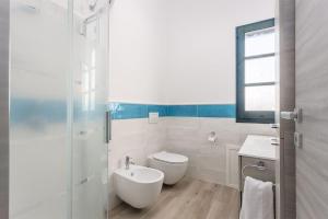 a white bathroom with a sink and a toilet at Domu Fama in Tertenìa +16 photos