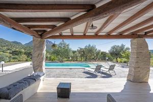 a patio with a swimming pool and two chairs at Domu Fama in Tertenìa