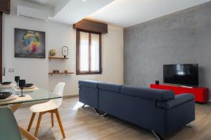 a living room with a blue couch and a table at Emilia Suite Space in Modena