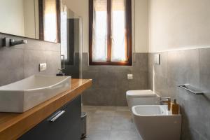 a bathroom with a sink and a toilet at Emilia Suite Space in Modena