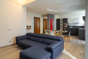 a living room with a blue couch and a kitchen at Emilia Suite Space in Modena