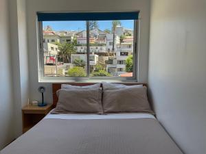 a bedroom with a bed and a large window at Hostal Recreo in Viña del Mar
