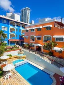 a swimming pool in front of a building at Hotel Areia de Ouro in Natal