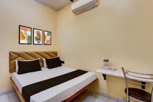 a small room with a bed and a desk at Hotel O Utsav In in Jabalpur