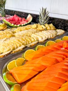 a buffet of food with fish and fruit in trays at Hotel Areia de Ouro in Natal