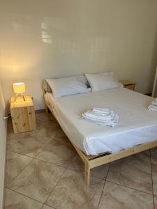 a bedroom with a bed with white sheets and a table at La Casa di Aira in Martina Franca