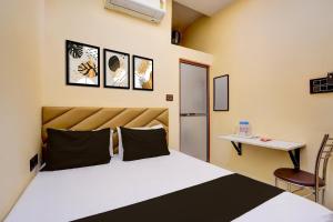 a bedroom with a bed and a table and a refrigerator at Hotel O Utsav In in Jabalpur
