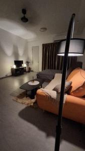 a living room with a couch and a lamp at Cozy Stay Studio in Shah Alam