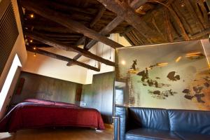 een slaapkamer met een bed en een bank in een kamer bij Hotel Boutique El Convento de Mave in Santa María de Mave