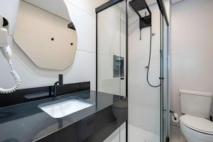a bathroom with a sink and a mirror at Estadia Sampa Butantã in São Paulo