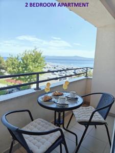 a table with food and two chairs on a balcony at Apartments Miraflor, city center in Crikvenica