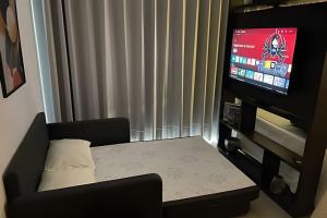 a living room with a table and a tv at Estadia Sampa Butantã in São Paulo +93 photos