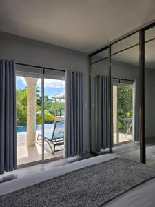 a bedroom with a bed and a view of a pool at Tranquility villas in Baie Sainte Anne +54 photos