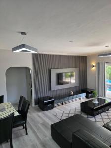 a living room with a couch and a tv at Tranquility villas in Baie Sainte Anne