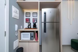 a kitchen with a refrigerator and a counter with a microwave at Estadia Sampa Butantã in São Paulo