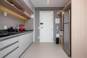 a kitchen with a refrigerator and a white floor at Estadia Sampa Butantã in São Paulo