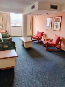 a waiting room with red chairs and tables at Hotel Lincoln Suites in Caracas