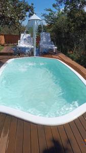 a large pool on a wooden deck with a hot tub at Chalé Aconchego da Lapinha Vista para Montanhas Piscina e Natureza in Santana do Riacho