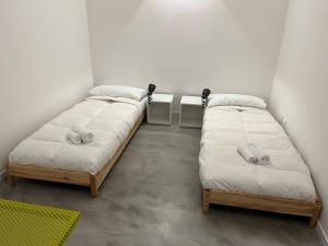 two beds in a room with white walls at La Casa di Mariano in Terrasini