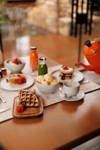 a table with breakfast foods and a tea kettle at Hotel Valle Dincanto in Gramado