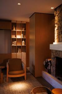 a living room with a chair and a fireplace at Hotel Valle Dincanto in Gramado